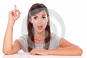 Surprised woman pointing up her finger