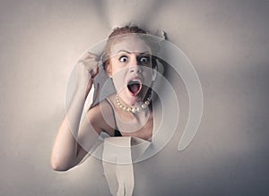 Surprised woman popping out from a white cardboard