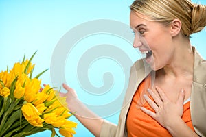 Surprised woman receive bouquet of yellow tulips photo