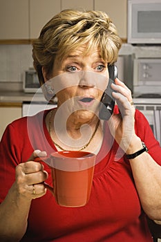 Surprised woman talks on phone