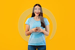 Surprised woman using mobile phone at studio