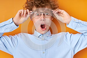 Surprised wonk boy in eyeglasses look at camera in shock photo
