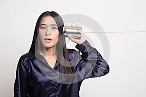 Surprised young Asian woman with tin can phone