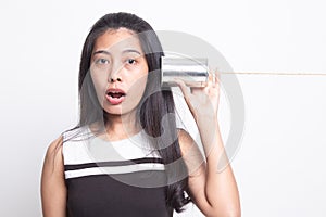 Surprised young Asian woman with tin can phone