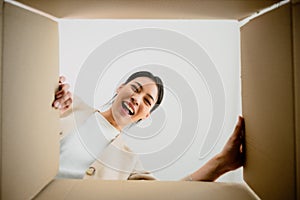 Surprised young asian woman unpacking