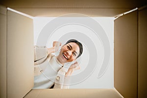 Surprised young asian woman unpacking