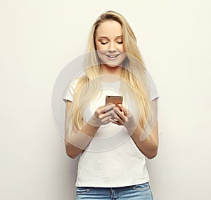 Surprised young blond hair woman holding mobile phone .