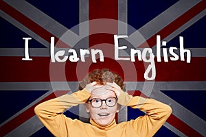 Surprised young boy against the UK flag background. Learning English concept