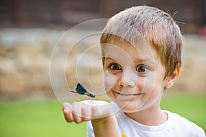 Surprised Young Boy and Dragonfly on his arm