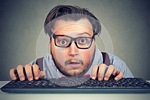 Surprised business man typing on key board photo