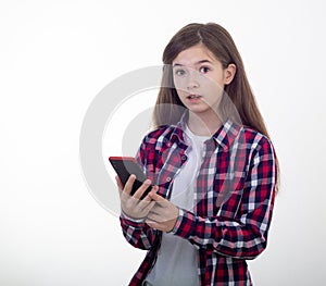 Surprised young girl holding phone on white background. Student with smartphone.