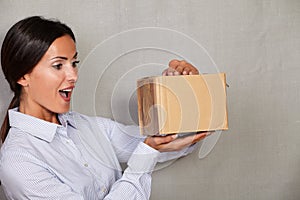 Surprised young lady opening a package