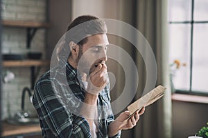 Surprised young man looking at old letters.