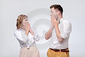 Surprised young man and mature woman looking at each other in full disbelief