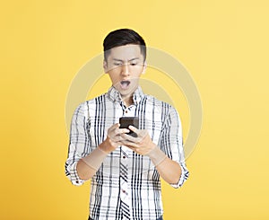 Surprised young man using smart phone
