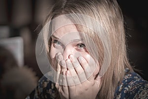 Surprised young woman covering her mouth with hands