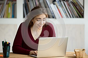 Surprised young woman excited by online win looking at laptop