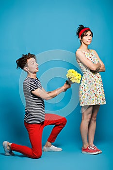 Surprised young woman getting flower from guy