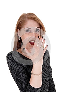 Surprised young woman, hand on face