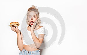 Surprised young woman holding a burger