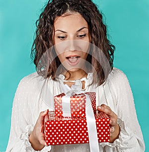 Surprised young woman holding Gifts in hands close up