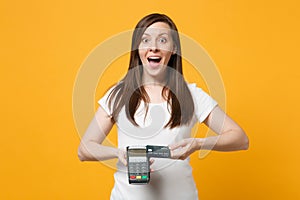 Surprised young woman holding wireless modern bank payment terminal to process and acquire credit card payments isolated