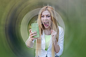 Surprised young woman looks into a smartphone.