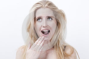 Surprised young woman with mouth open against white background