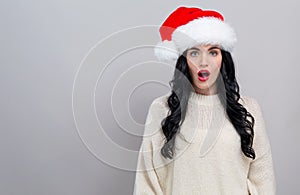Surprised young woman in a Santa hat