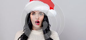 Surprised young woman in a Santa hat