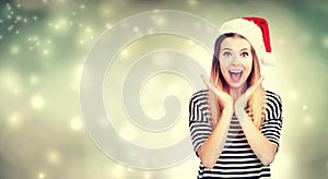 Surprised young woman with Santa hat posing