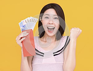 Surprised young woman showing the red envelope and money