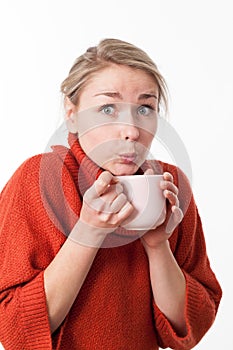 Surprised young woman sipping a hot tea,coffee,chocolate