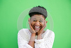 Surprised young woman smiling with hands on face