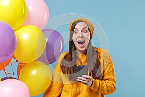 Surprised young woman in sweater hat posing isolated on blue background. Birthday holiday party, people emotions concept