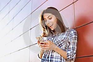 Surprised young woman using smart phone outdoors. Coffee break