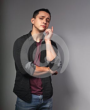 Surprising happy brunette man thinking and have and idea holding the finger on dark grey background. Closeup