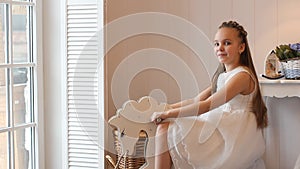 Surprisingly beautiful teenage girl in a smart dress in the interior of the house.