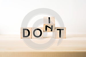 Surreal abstract geometric wooden cube with word DON`T and DO IT concept on wood floor and white background