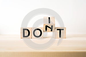 Surreal abstract geometric wooden cube with word DON`T and DO IT concept on wood floor and white background photo