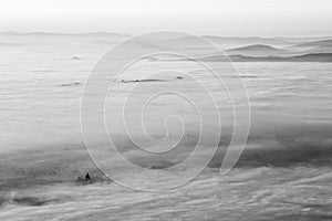 Surreal aerial view of Santa Maria degli Angeli church in Assisi, Italy, above a sea of fog