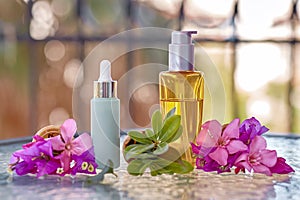 Surreal bright pink bougainvillea flowers in an ice cream cone and mock up of cosmetic bottles. Oil cosmetic bottle and