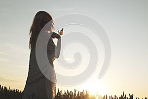 surreal encounter between a woman and free butterfy flying in the middle of nature