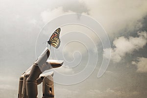 Surreal encounter between a wooden hand and a colourful butterfly