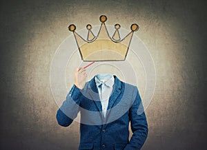 Surreal image as a businessman with invisible face holding a pencil in his hand draw crown symbol instead of head. Business