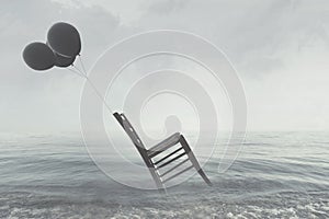 Surreal image of a chair held in balance by flying black balloons