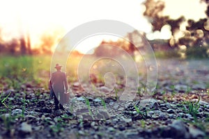 Surreal image of mysterious man walking alone in during sunset