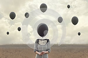 Surreal image of woman and blacks balloons flying