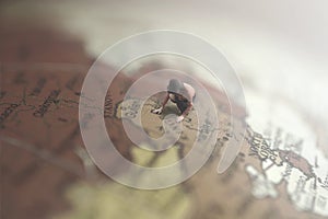 Surreal image of a woman looking for a destination in a giant globe