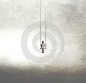 Surreal image of a woman on a swing suspended in the sky